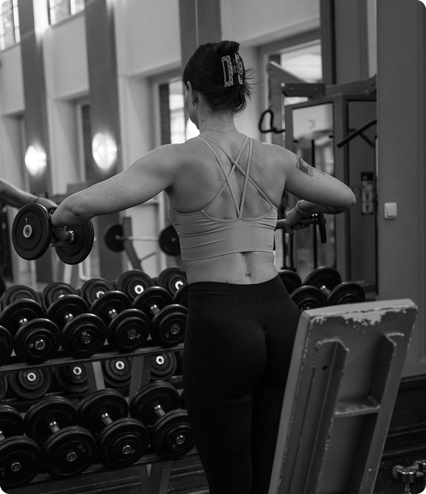 Mitglied des Madison Fitnessstudios Hildesheim bei der Durchführung einer Schulterübung mit Kurzhanteln.