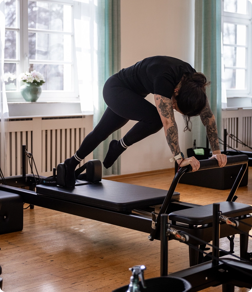 Reformer Pilates Trainerin bei der Durchführung einer Übung