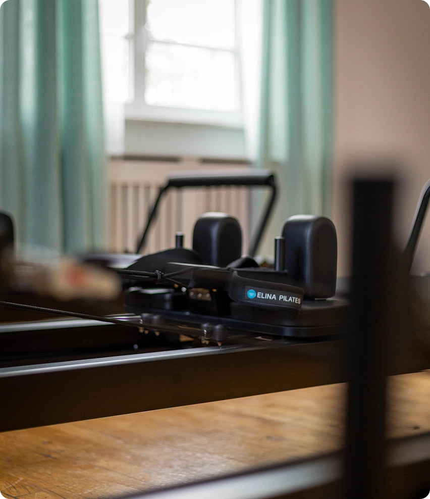 Schwarzes Reformer Pilates Gerät von der Seite